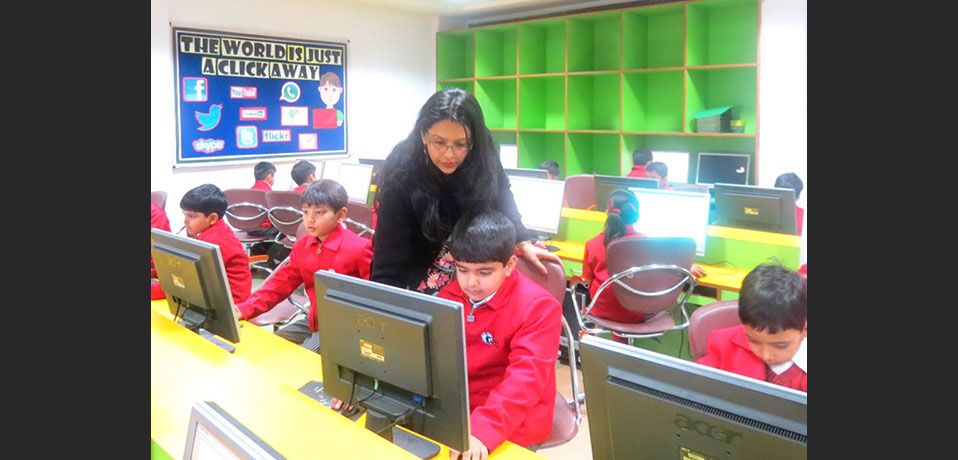 best private school in rohini,a teacher teaching the students in computer lab
