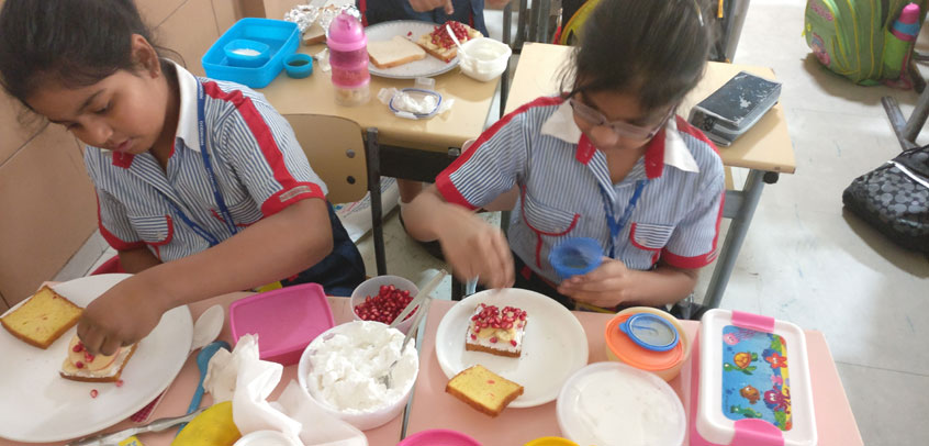 best primary school in delhi,students of primary wing having lunch in their class room
