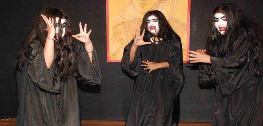 school with theatre in delhi, students performing horror play in school theatre
