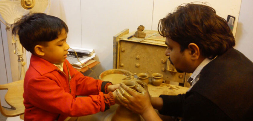 school best in extra curricular activities,teacher and student enjoying pottery class
