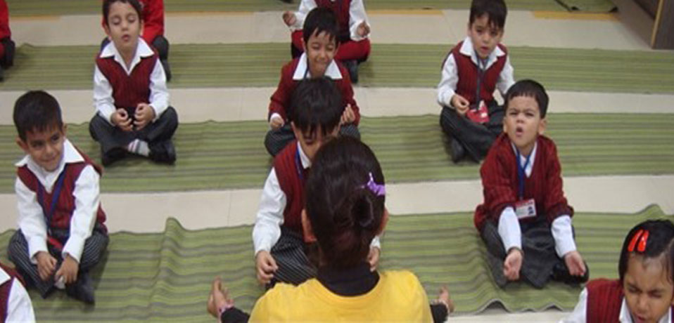 the image shows the students of junior wing and teacher doing yoga,best private school in rohini
